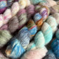 Close-up of multicolored yarn skeins in shades of pink, blue, green, and orange.