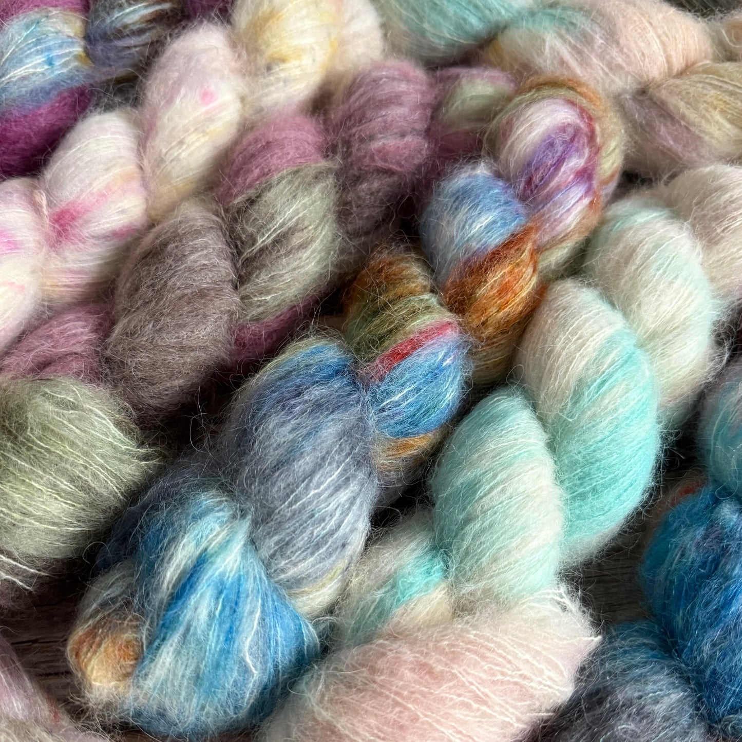 Close-up of multicolored yarn skeins in shades of pink, blue, green, and orange.