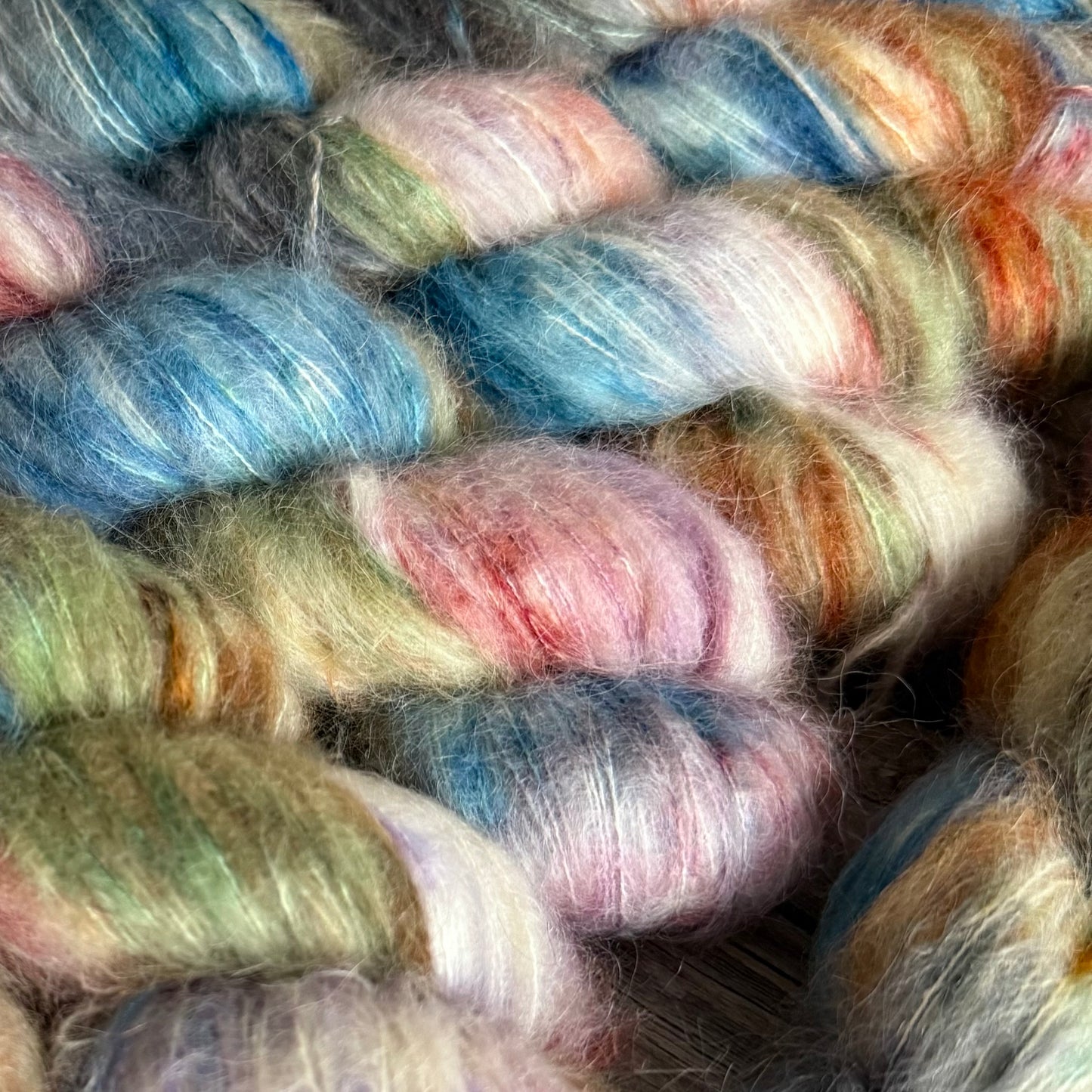 Close-up of multicolored yarn skeins with pastel shades.