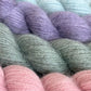 Close-up of pastel-coloured Baa Ram Ewe Mowool yarn skeins including purple, green, and pink.
