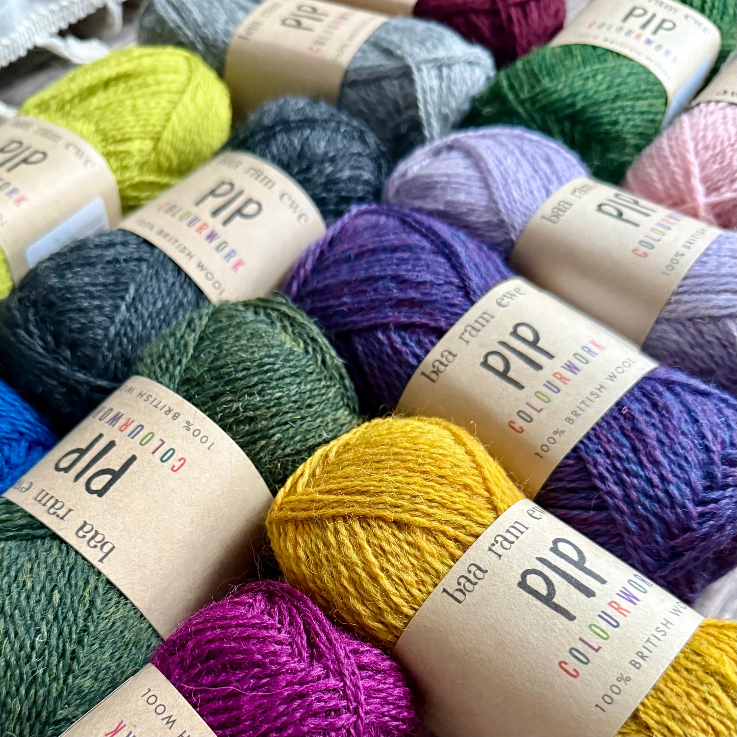 Assorted colorful yarn balls with 'PIP Colourwork' labels.