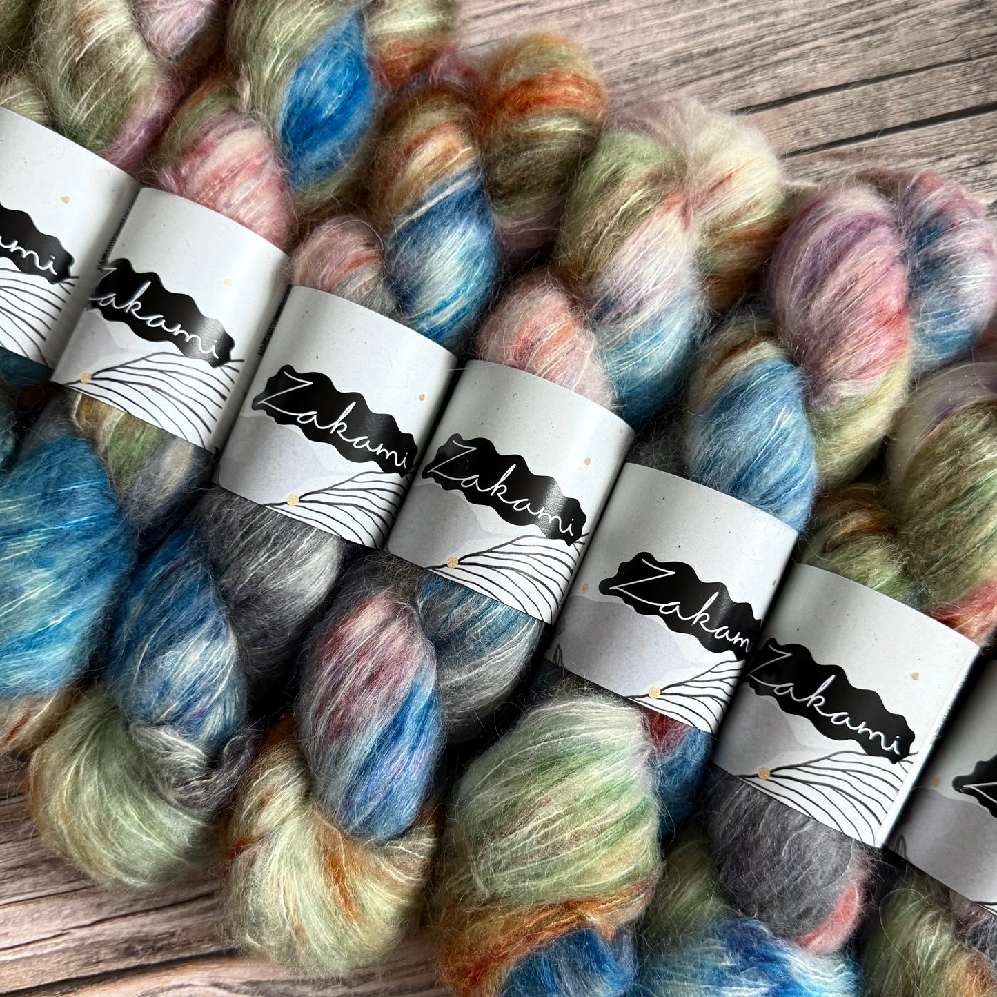 Colorful yarn skeins with labels on a wooden surface